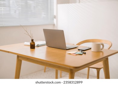 Laptop and documents on wooden work desk at home, comfortable workspace, workplace with computer in apartment. work at home concept 