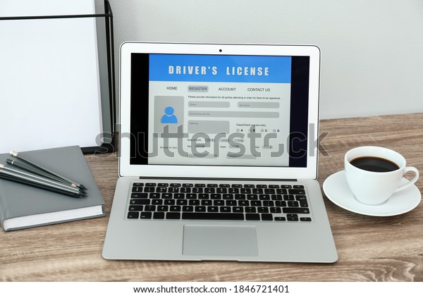 Laptop with driver\'s license application form on\
table in office