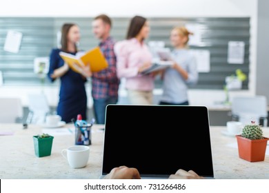 Laptop From The First Person On The Background Of A Group Of Office Workers