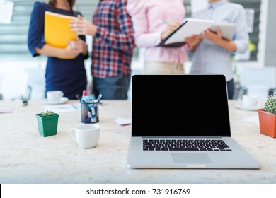 Laptop From The First Person On The Background Of A Group Of Office Workers