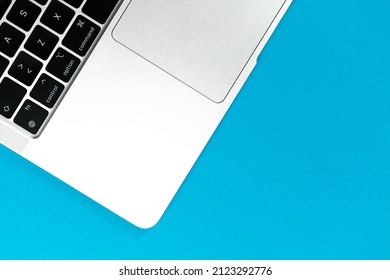 Laptop Flat Lay Blue Background. Office Workspace Table, Minimal Design Concept. Top View, Copy Space