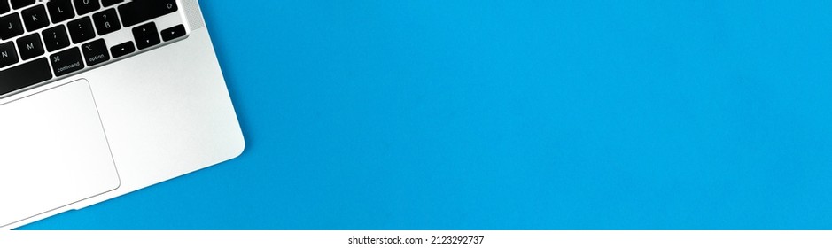 Laptop Flat Lay Blue Banner Background. Office Workspace Table, Minimal Design Concept. Top View, Copy Space