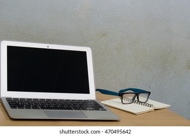 Laptop and glasses on wood table