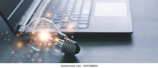 Laptop and glowing light bulb. Self learning or education knowledge and business studying concept. Idea of learning online or e-learning from home. - Shutterstock ID 1945188853