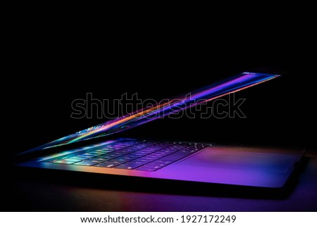 a laptop half closed bright and glowing
