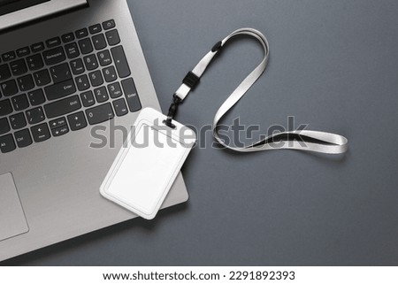 Laptop and id card on belt, dark background. Template for design. Top view