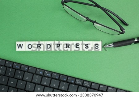 laptop keyboard, glasses and pen with Wordpress alphabet words. Wordpress concept