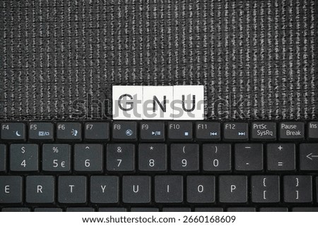 A laptop keyboard with GNU words. operating system composed of free software, developed by the GNU Project.