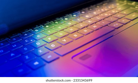 Laptop keyboard with vibrant hues illuminating the keys, wallpaper with colorful lights casting on the computer keyboard, dynamic technology concept, close-up - Shutterstock ID 2331343699