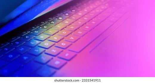 Laptop keyboard with vibrant hues illuminating the keys, wallpaper with colorful lights casting on the computer keyboard, dynamic technology concept, close-up, copy space - Shutterstock ID 2331541911