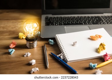 Laptop, light bulb and notepad on desktop