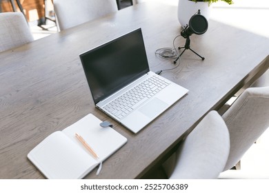 Laptop, microphone, and notebook on table, ready for home recording session. Workspace, remote working, home office, technology, creativity, podcast - Powered by Shutterstock