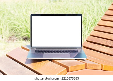 Laptop Mockup. Notebook With White Screen Morning City Urban Public Space On Background In Park Bench. Urban, And Remote Work And Study Concept. Empty Copy Space, Blank Screen Modern Laptop.