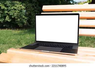 Laptop Mockup. Notebook With White Screen Morning City Urban Public Space On Background In Park Bench. Urban, And Remote Work And Study Concept. Empty Copy Space, Blank Screen Modern Laptop.