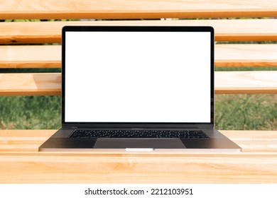 Laptop Mockup. Notebook With White Screen Morning City Urban Public Space On Background In Park Bench. Urban, And Remote Work And Study Concept. Empty Copy Space, Blank Screen Modern Laptop.