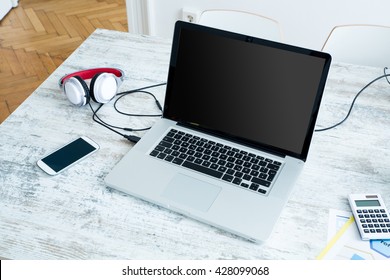 A Laptop in a modern home office setup on a wooden Table.
