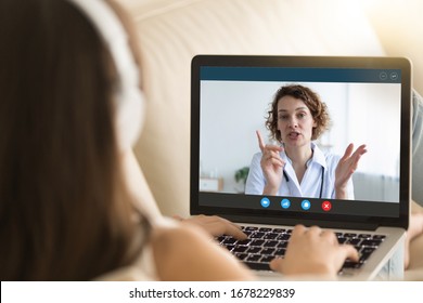 Laptop monitor view over woman shoulder, girl in headphones listens female therapist, medic gives recommendation how protect people during corona virus ncov epidemic outbreak pandemic disease concept - Shutterstock ID 1678229839