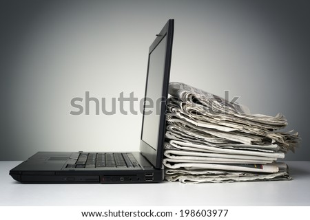 Laptop and newspaper concept for internet and electronic online news