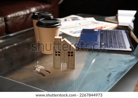 Laptop, newspaper, diary, notebook, cups of coffee on a glass desktop top view. Workplace in the office or at home. Work desk in the morning, preparation for work. ?ffice scenes. Real estate auction.