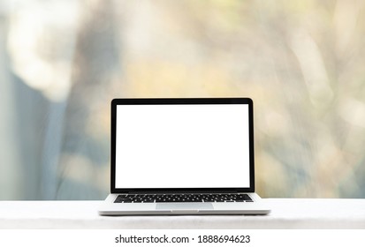 Laptop Or Notebook With Blank Screen On Wooden Table In Blurred Background In Modern Home Or Office, Bokeh Light And Sunlight In The Morning.