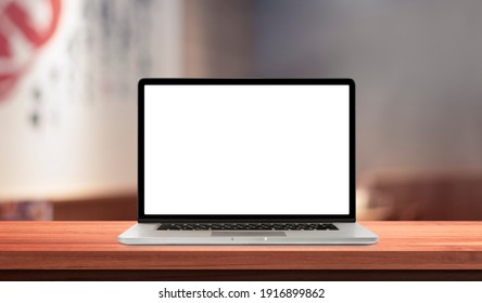 Laptop or notebook with blank screen on wood table in blurry background japan restaurant ,nature orange bokeh and sunlight in morning.