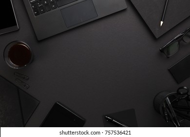 Laptop And Office Supplies At Dark Gray Desk