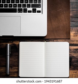 Laptop On Leather Desk Mat, Notebook And Pen On Wood Table