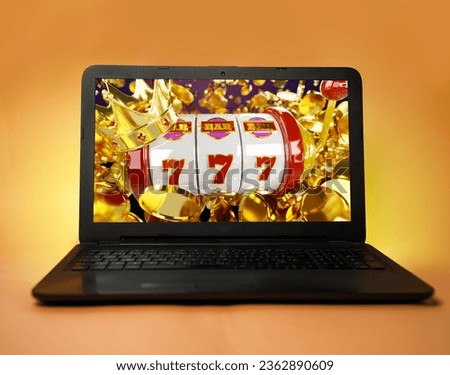 Laptop on orange yellow background, casino winnings concept, 777 and bunch of coins flying on the screen 
