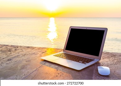 Laptop On Table At Sea Sunset In Summer Time