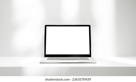 Laptop on white table platform with lights isolated, laptop white screen mock up empty blank space for design and advertisement. - Shutterstock ID 2363570439