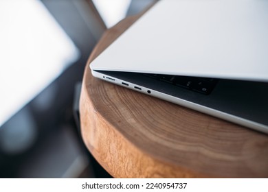laptop on wooden table, laptop charging ports. MagSafe 3. laptop charger. MacBook 14 pro 2022 air
