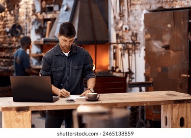 Laptop, paperwork and man metal worker in workshop reading industry contract for project. Technology, professional and blacksmith work on computer and documents for industrial trade career in garage. - Powered by Shutterstock