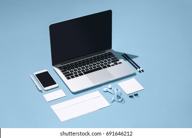 The laptop, pens, phone, note with blank screen on table स्टॉक फ़ोटो
