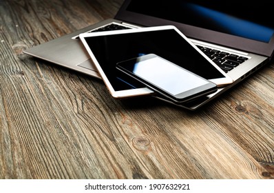 Laptop With Phone And Tablet Pc On Wooden Desk
