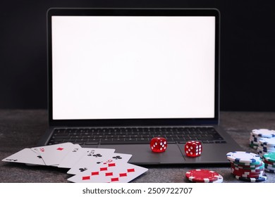 Laptop, poker chips, playing cards and dices on grey table. Online game - Powered by Shutterstock