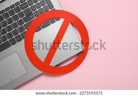 Laptop with prohibition sign on pink background