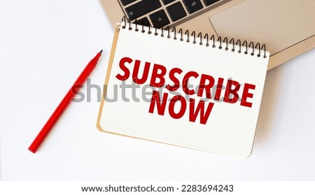Laptop, red pen and notepad with text subscribe now in the white background