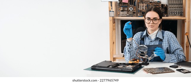 Laptop repair. Repairman working in technical support fixing computer laptop using multimeter or voltage meter. Copy space. Banner - Shutterstock ID 2277965749