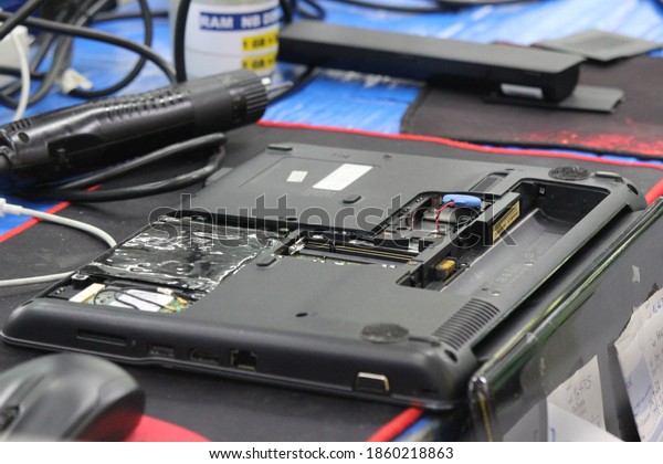 Laptop repair technician\
removing the lithium polymer battery from a laptop to perform the\
repair