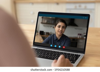 Laptop Screen View Of Millennial Female Of Indian Ethnicity Sit At Home Kitchen Call Friend By Video Link Talk Chat. Serious Young Mixed Race Woman Hold Online Conversation With Colleague