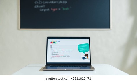 Laptop showing a computer programme placed on a desk in a children’s coding classroom. Still life shot of a lesson setup in a kids coding academy.