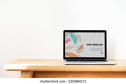 Laptop Showing Website Template On A Wooden Table