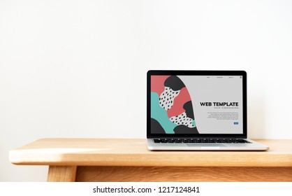 Laptop Showing Website Template On A Wooden Table