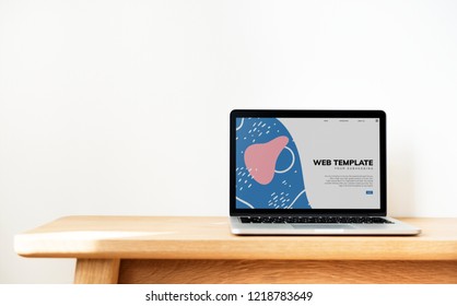 Laptop Showing Website Template On A Wooden Table