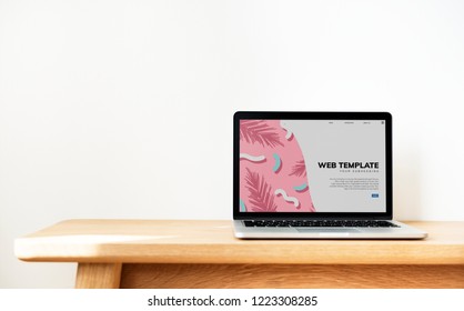 Laptop Showing Website Template On A Wooden Table