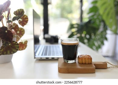 Laptop side view and coffee glass mug and dessert indoor working - Shutterstock ID 2256628777