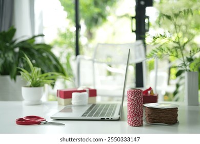 Laptop side view and gift box and thread, gift preparation  - Powered by Shutterstock