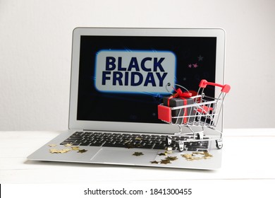 Laptop And Small Cart On White Table. Black Friday Sale Online