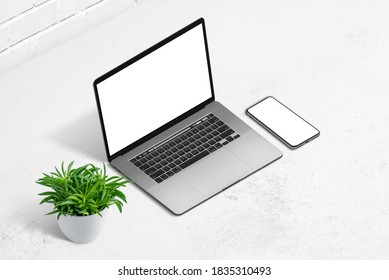 Laptop And Smart Phone Mockup. Isometric Position. White Office Desk With Plant Beside