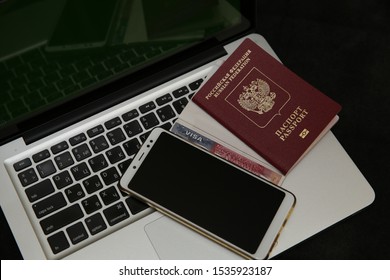 Laptop And Smartphone And Visa Stamp, American Visa, Travel Passport And Russian Passport. Business And Vacation And Travel Concept. Flat Lay. Top View.